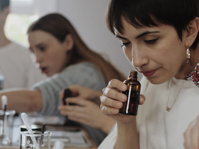 A close up of a person smelling essential oil at a candle making class